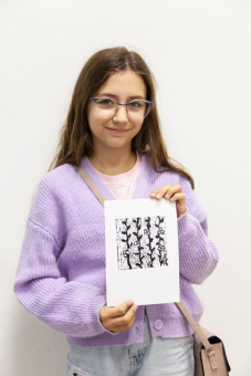 Dziewczyna prezentuje swój linoryt.