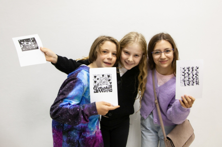 Troje nastolatków prezentuje swoje prace.