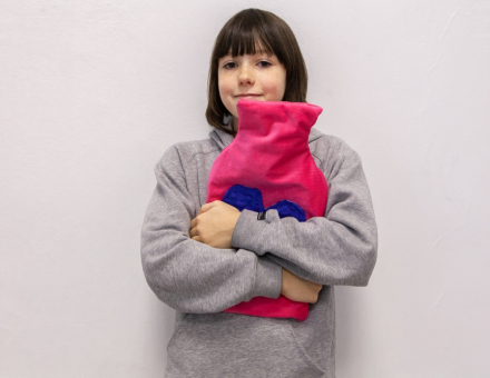 Dziewczynka prezentuje zrobiony przez siebie termofor.