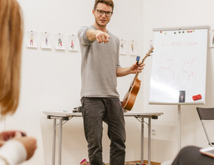 Instruktor wskazuje palcem w stronę jednej z warsztatowiczek.