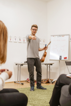 Instruktor wskazuje palcem w stronę jednej z warsztatowiczek.