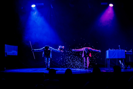 Podświetlona na niebiesko scena. Dwaj magicy kłaniają się publiczności.