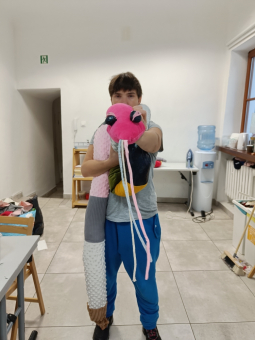 Mężczyzna prezentuje obciążeniowy przytulak, który samodzielnie uszył.