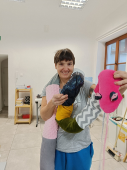 Kobieta prezentuje gotową przytulankę obciążeniową - węża.