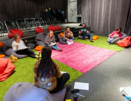 Uczestnicy spotkania siedzą w kręgu.