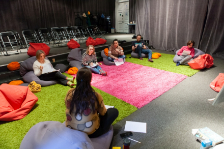 Uczestnicy spotkania siedzą w kręgu.