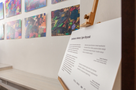 Tablica informacyjna z opisem wystawy i biografią Igora Bryzka.