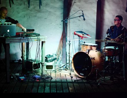 Na scenie są dwaj muzycy. Perkusista i klawiszowiec.