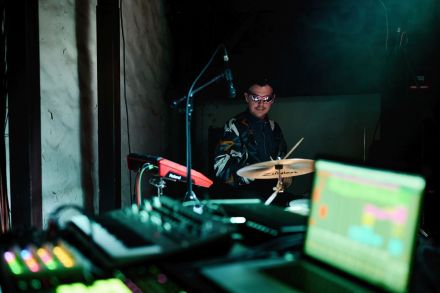 Zbliżenie na perkusistę w okularach i dresie.