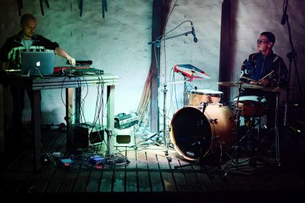 Na scenie są dwaj muzycy. Perkusista i klawiszowiec.