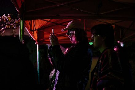 Dziewczyna spośród publiczności robi zdjęcia telefonem podczas koncertu.