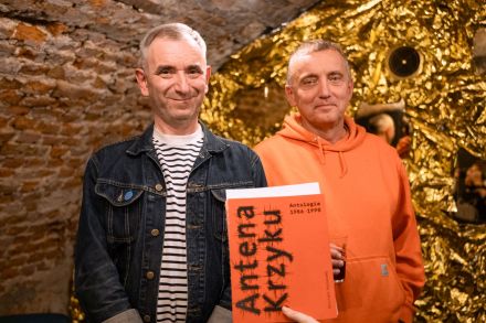 Goście spotkania pozują do zdjęcia z książką, której są autorami.