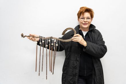 Kobieta prezentuje swój dzwonek wietrzny.