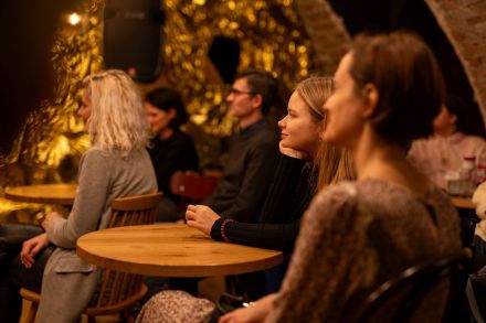 Dwie kobiety słuchają z zainteresowaniem rozmowy.