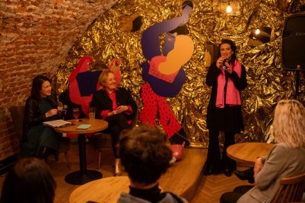 Kobieta zadaje pytanie przez mikrofon.