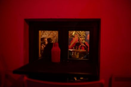 Ludzie zgromadzeni na spotkaniu widziani są przez okno.