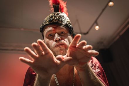 Artysta ma na głowie hełm z pióropuszem.