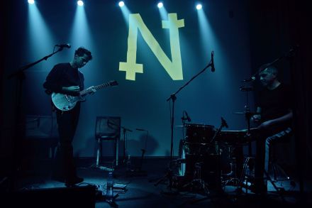 Gitarzysta chodzi po scenie. Kieruje się w stronę perkusisty.