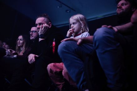 Dziewczynka patrzy z zaciekawieniem na muzyków.