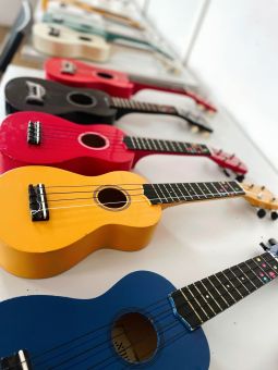 Na stole leżą kolorowe ukulele.
