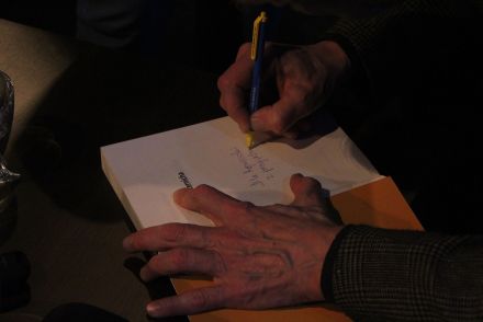 Riabczuk składa podpis w książce.