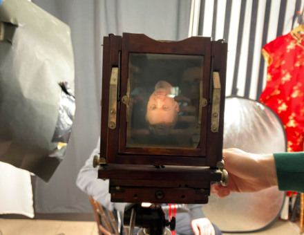 Fotografia mężczyzny umieszczona na tabliczce w aparacie sprzed stu lat. Widzimy ją do góry nogami.