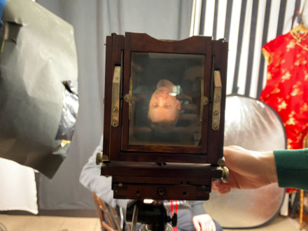 Fotografia mężczyzny umieszczona na tabliczce w aparacie sprzed stu lat. Widzimy ją do góry nogami.