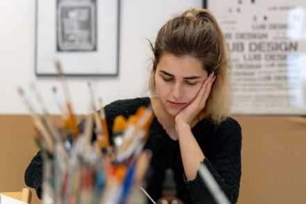 Dziewczyna siedzi przy stole zamyślona.