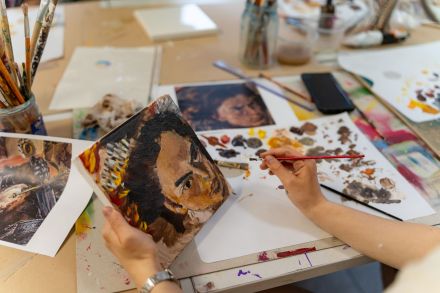 Kobieta przerysowuje twarz z obrazu.