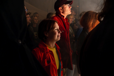 Kobieta i mężczyzna stoją pod sceną i śmieją się.