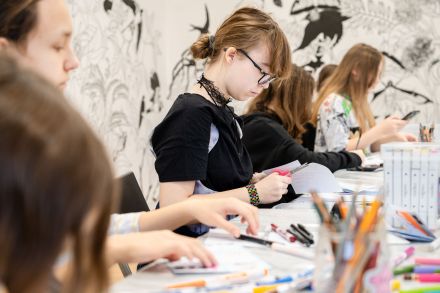 Uczestniczki warsztatów rysują swoją książkę.
