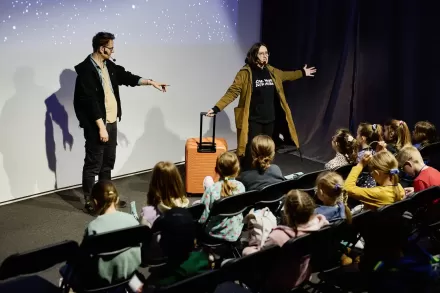 Kobieta trzyma walizkę podróżną. Mężczyzna jest zdziwiony. 