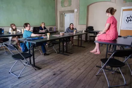Prowadząca warsztatu z profilu. Słuchają jej uczestnicy.