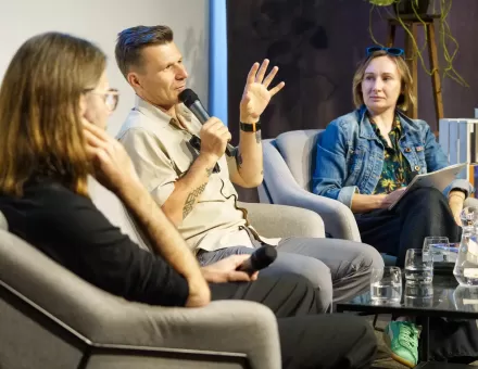 Autor książki wypowiada się do mikrofonu i gestykuluje.