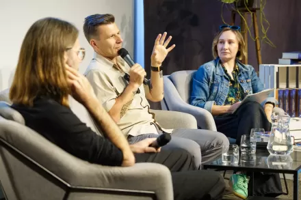 Autor książki wypowiada się do mikrofonu i gestykuluje.