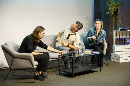 Kobieta i dwaj mężczyźni prowadzą dyskusję. 