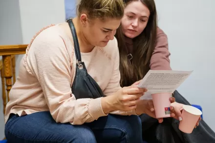 Dwie kobiety czytają ulotkę do wystawy.