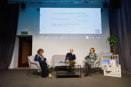 Przy stole siedzą dwie kobiety i mężczyzna. 