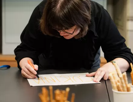 Kobieta robi notatki przy stole.