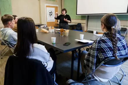 Prowadząca mówi do warsztatowiczów i warsztatowiczek. Bardzo przy tym gestykuluje. 