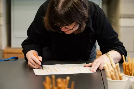 Kobieta robi notatki przy stole.