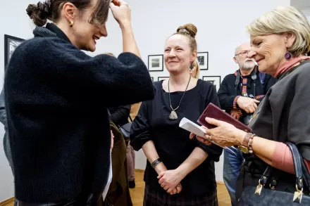 Artystka rozmawia z dwiema kobietami.