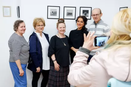 Kobieta robi zdjęcie grupie ludzi z artystką.