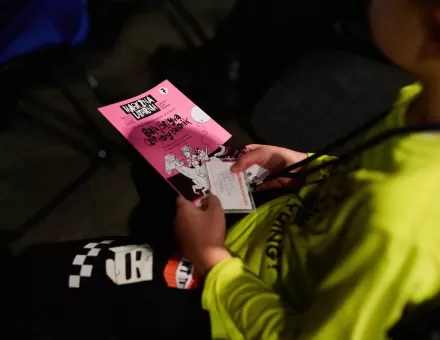 Chłopiec trzyma na kolanach książeczkę magicznej latarni.