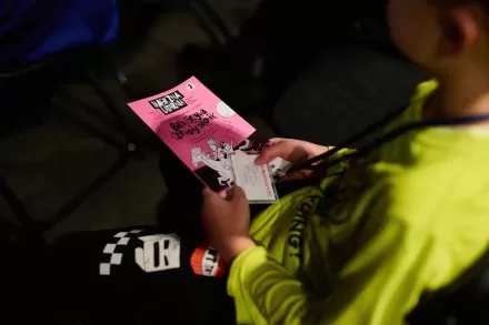 Chłopiec trzyma na kolanach książeczkę magicznej latarni.