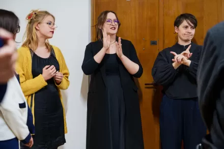 Przy drzwiach stoją artystka, kuratorka wystawy i tłumaczka PJM.