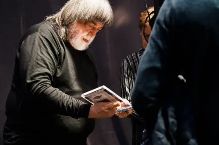 Piosenkarz trzyma w ręce dwie płyty.