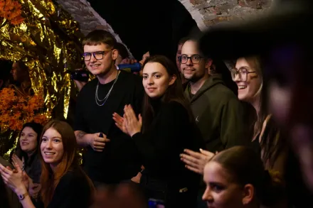 Grupa młodzieży klaszcze i się uśmiecha.