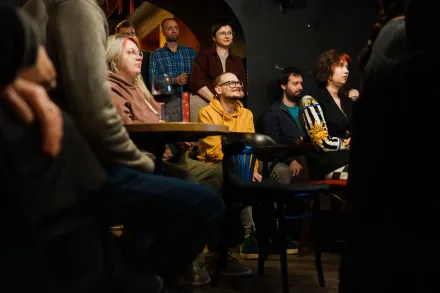 Publiczność siedzi przy stolikach.