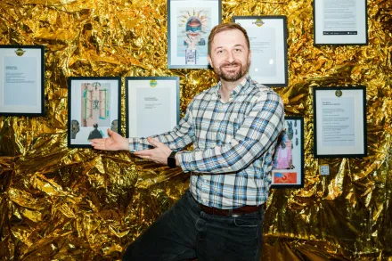 Mężczyzna wskazuje na kartki z wierszami. 